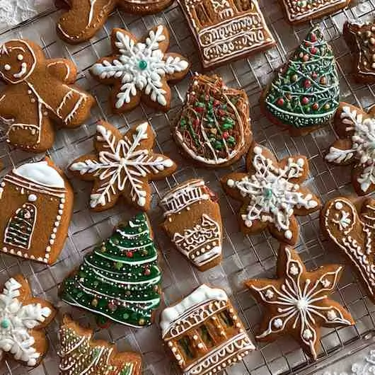 Adding brown sugar to gingerbread cookie dough in a wooden bowl.